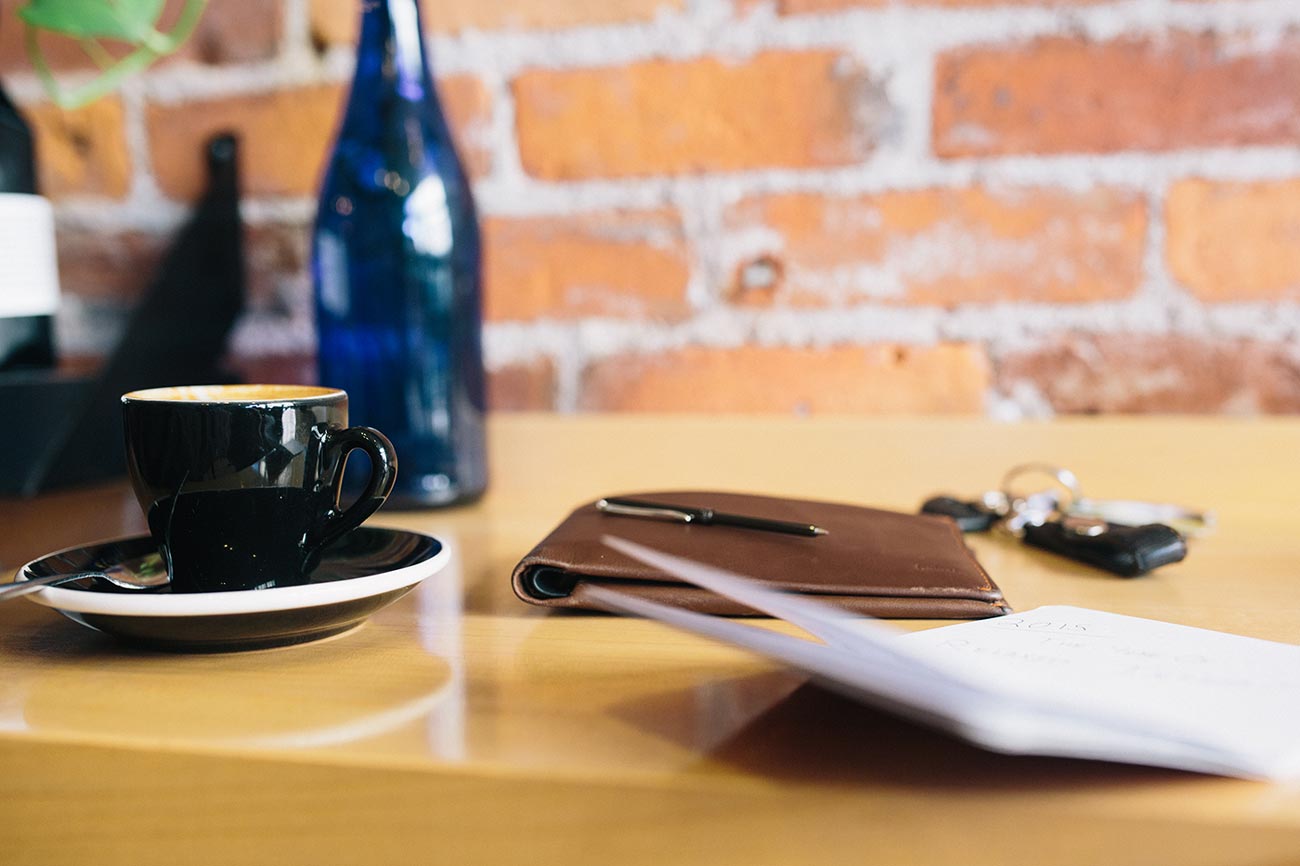 Cup of coffee sitting on table near notebook