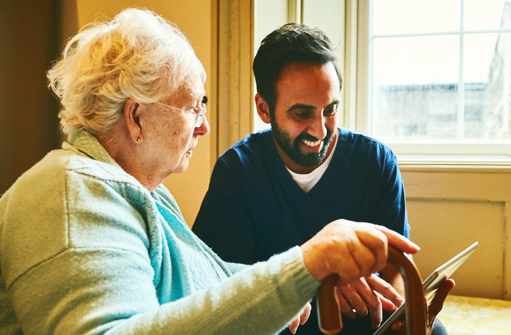 A photo representing an older lady using a tablet device. 