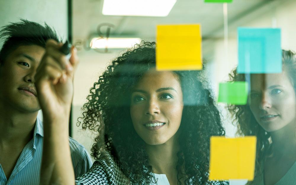 woman drawing on a website redesign board with sticky notes