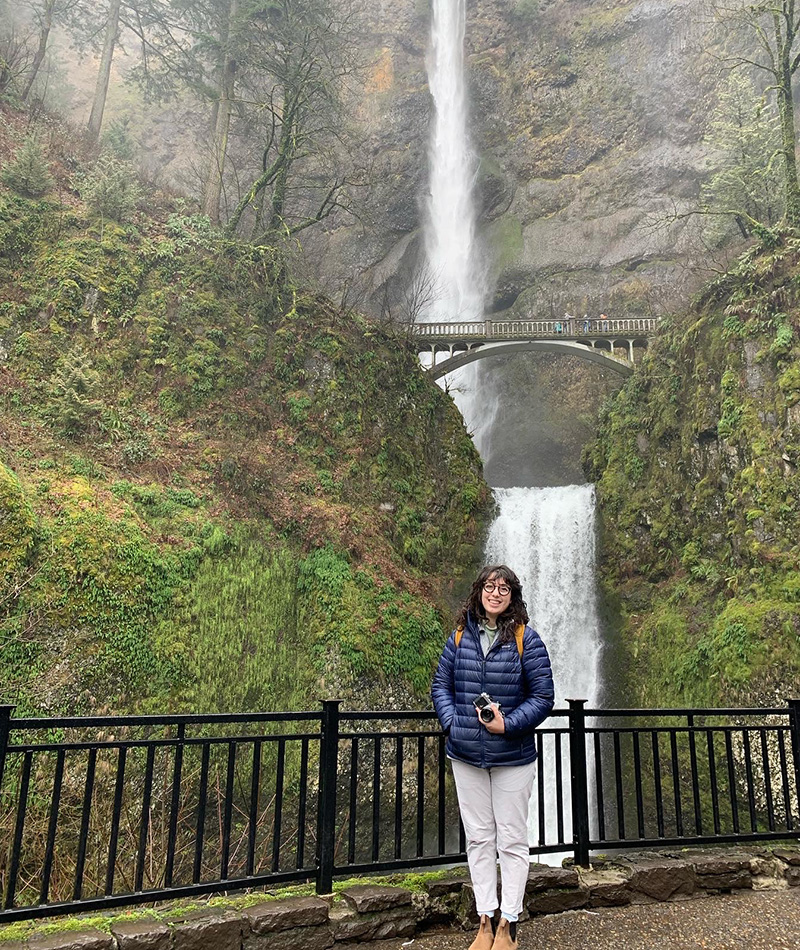 Hannah standing under a waterfall