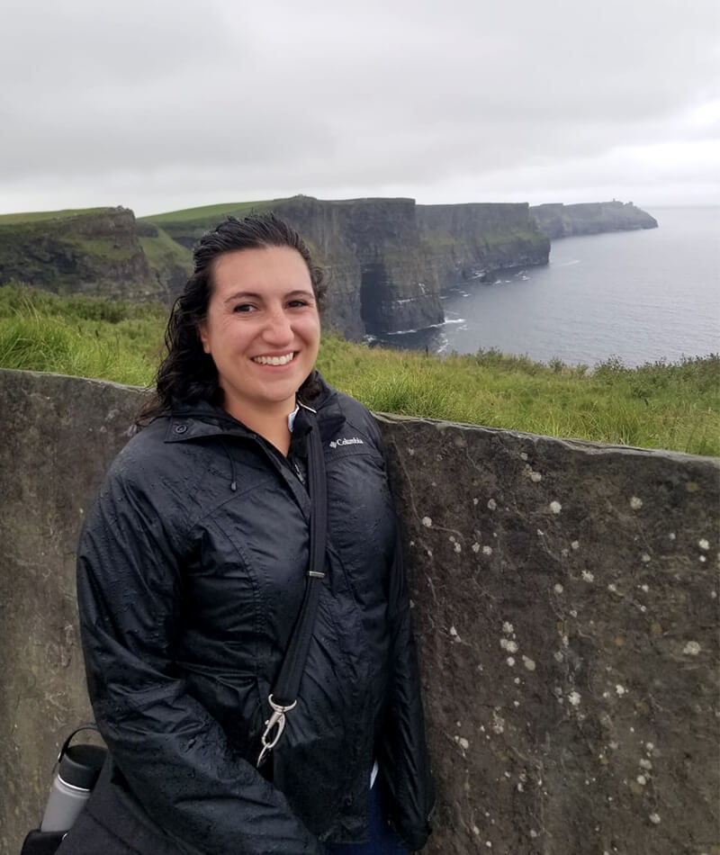 Daniela standing in front of a cliff in Ireland.