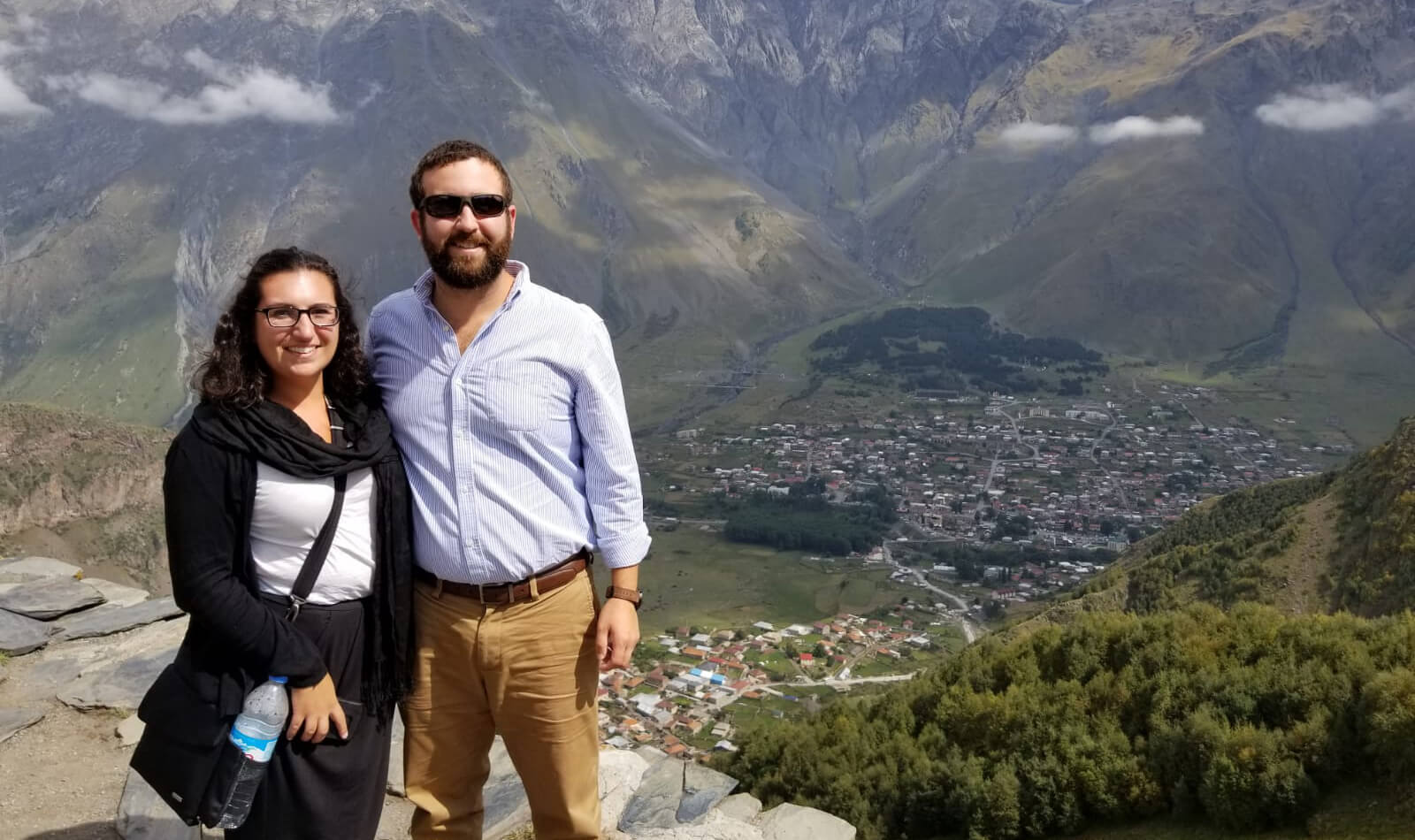 Daniela and her husband with a view of a city in Peru behind them. 