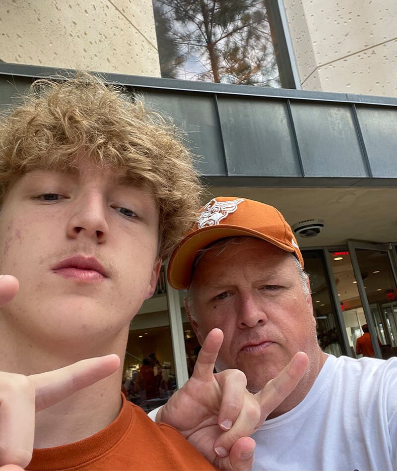 Trey and his son make the hand gesture for the University of Texas.
