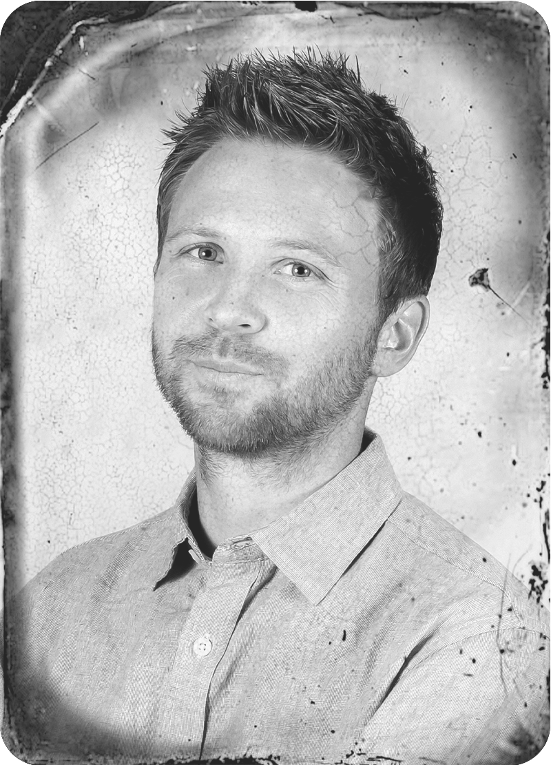 Kyle standing with arms crossed in vintage styled photo